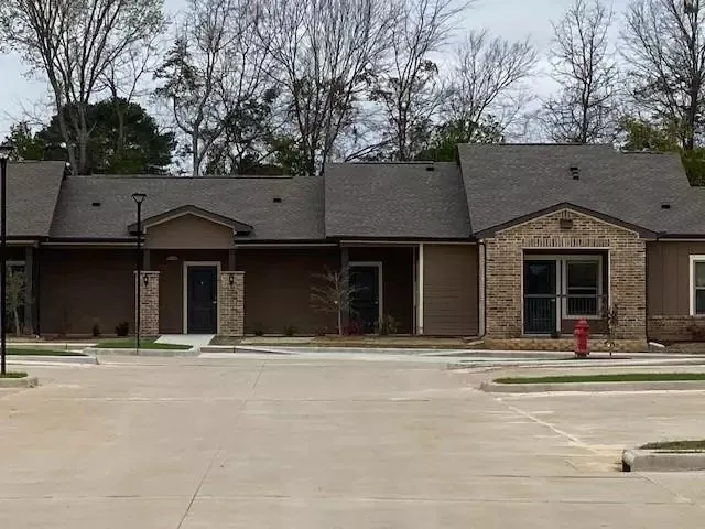 a front view of a house with a large tree