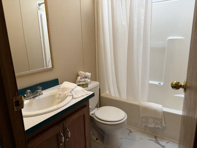a bathroom with a sink a toilet and shower curtain