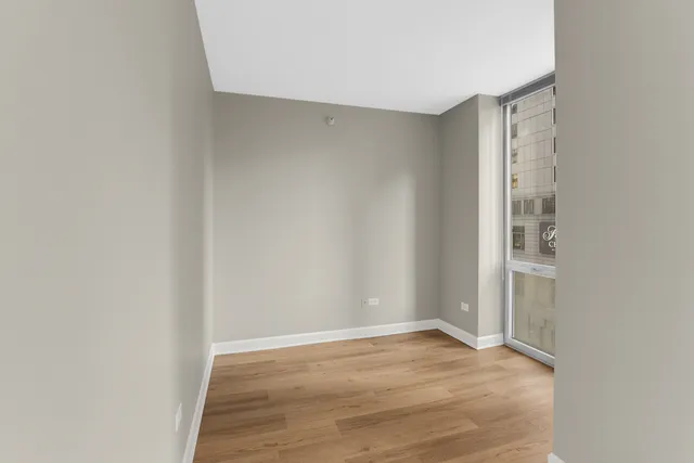 a view of an empty room with wooden floor