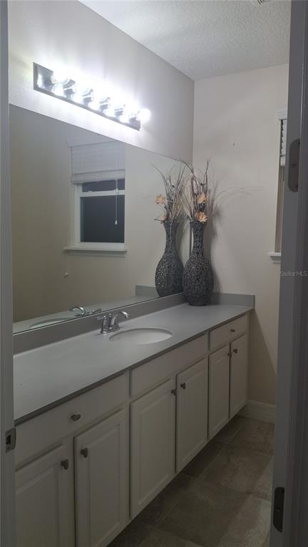 2840 Chantilly Avenue Kissimmee, FL 34741 - Photo 16 of 22 a bathroom with a sink and a mirror