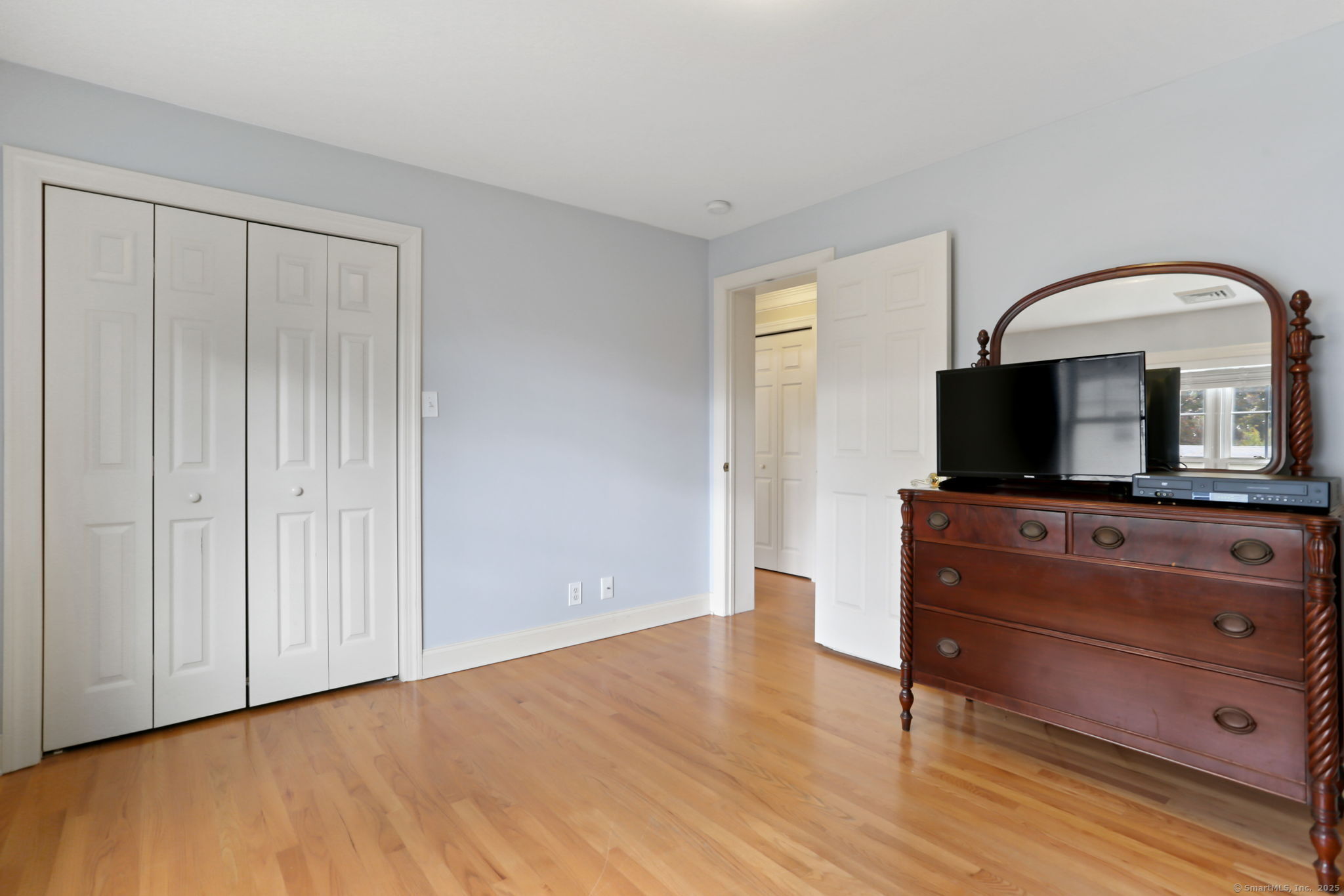 25 Country Road, Unit 25 Fairfield, CT 06824 - Photo 28 of 40 a room with a dresser and a mirror