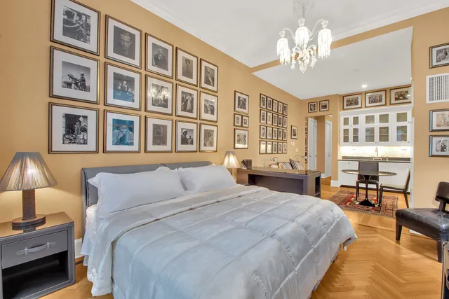 a bedroom with a large bed and a chandelier
