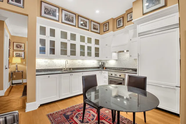 a kitchen with stainless steel appliances granite countertop a dining table and chairs