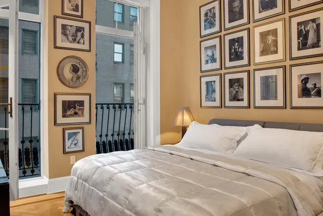 a bedroom with a bed and a lamp on dresser