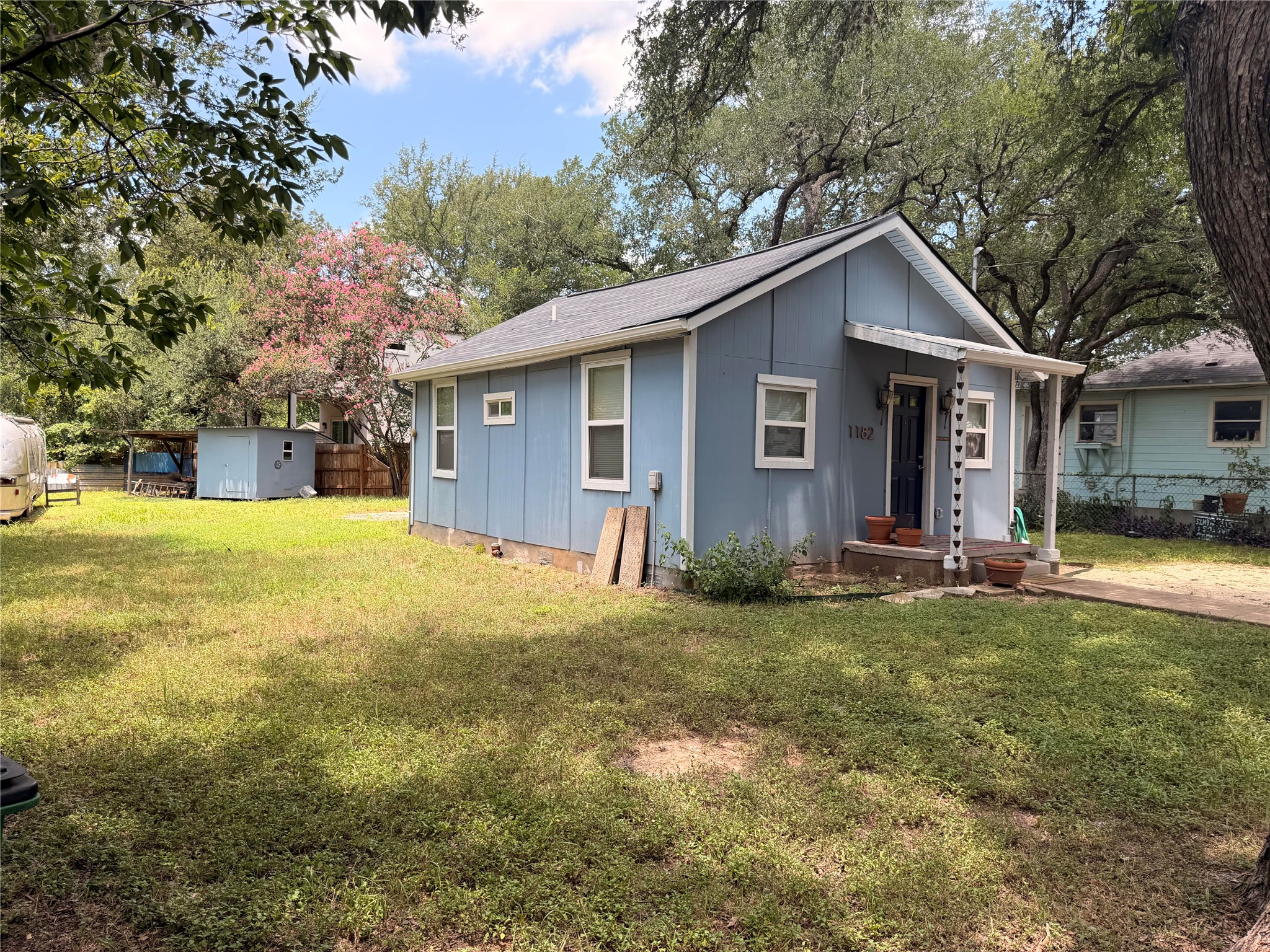 1182 Pandora Street Austin, TX 78702 - Photo 18 of 19 A charming cottage with a welcoming front porch and a spacious, verdant yard, perfect for outdoor enjoyment.