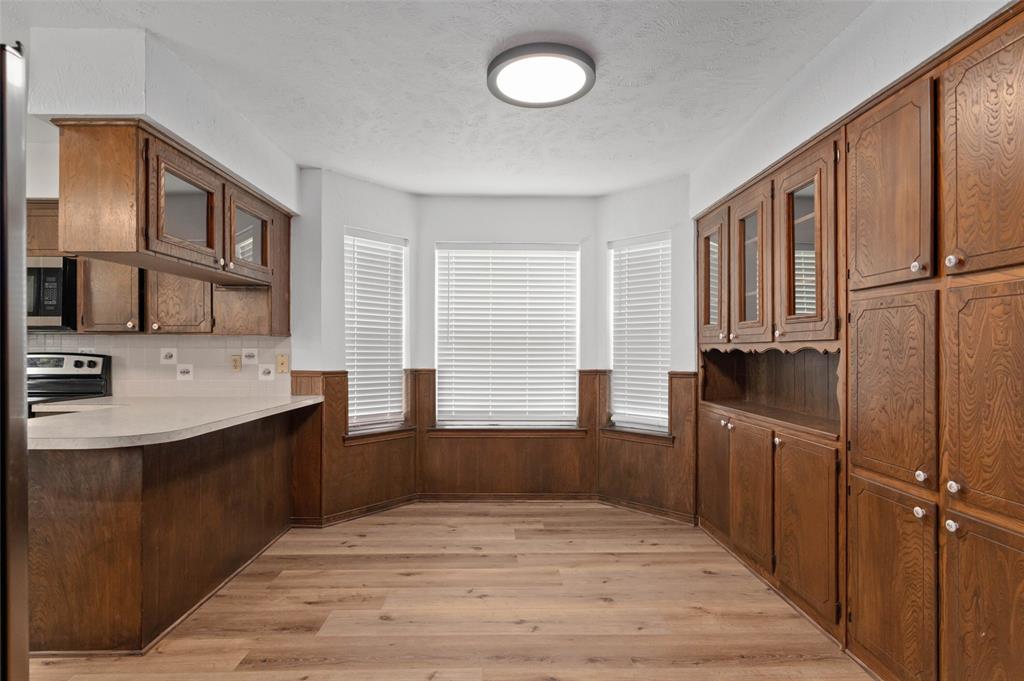 301 East 6th Street Krum, TX 76249 - Photo 15 of 29 Dining area off the kitchen with beautiful custom wood cabinets and new wood-type flooring.