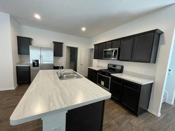 a kitchen with stainless steel appliances kitchen island a sink refrigerator and microwave