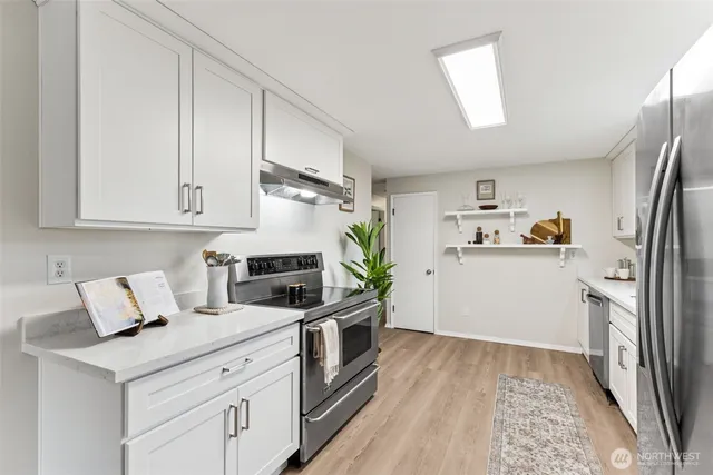 a kitchen with stainless steel appliances a refrigerator sink and cabinets