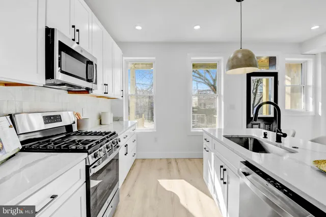 a kitchen with stainless steel appliances a sink stove and cabinets