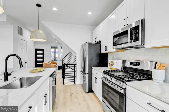 a kitchen with stainless steel appliances granite countertop a sink dishwasher a refrigerator and a stove