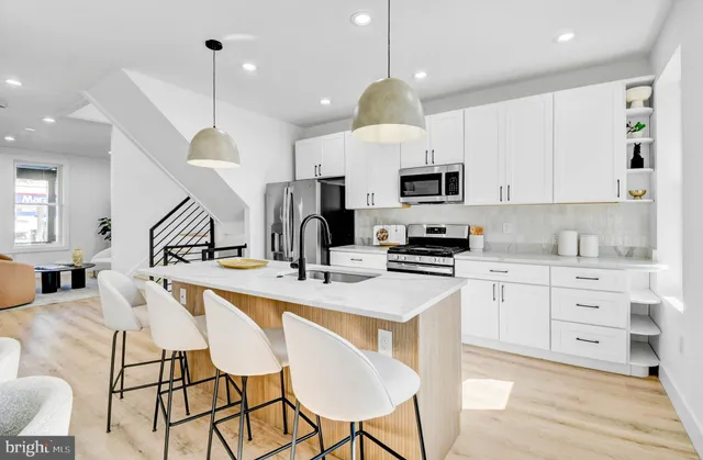 a kitchen with stainless steel appliances granite countertop a sink a stove a refrigerator and cabinets