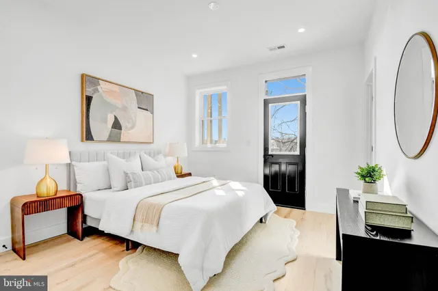 a bedroom with a bed and dresser with mirror