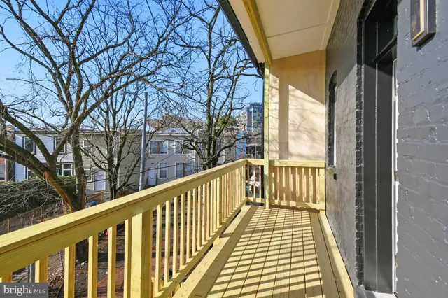 a view of a balcony with wooden floor and fence