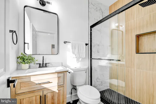 a bathroom with a sink a toilet and shower