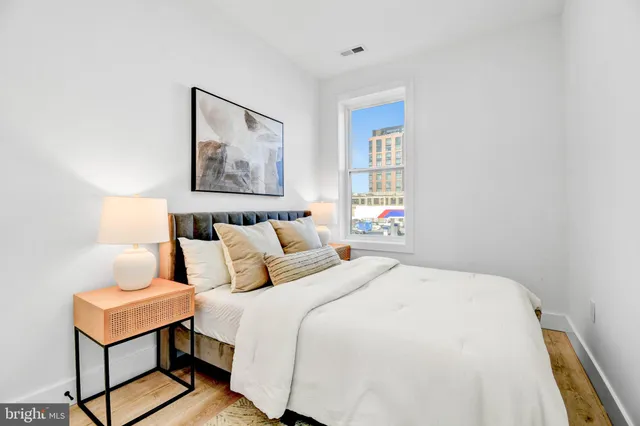 a bedroom with bed and wooden floor