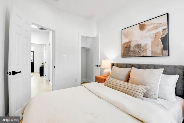 a bedroom with a bed and a painting on the wall