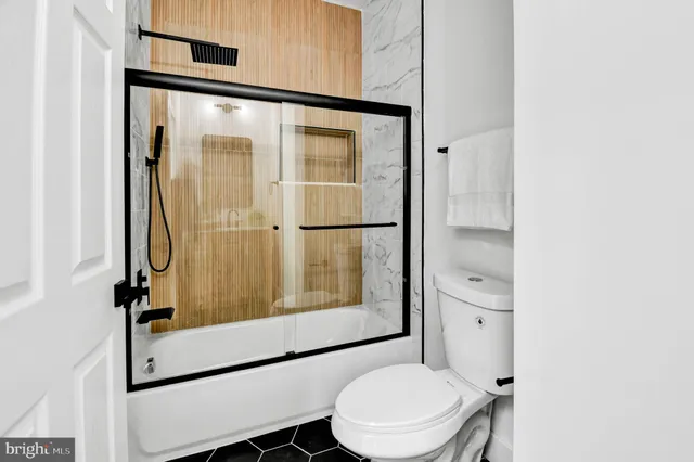 a bathroom with a toilet shower vanity and a sink