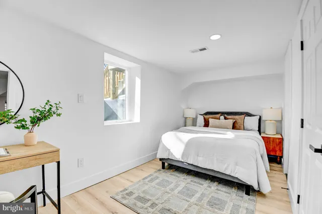 a bedroom with a bed and a potted plant