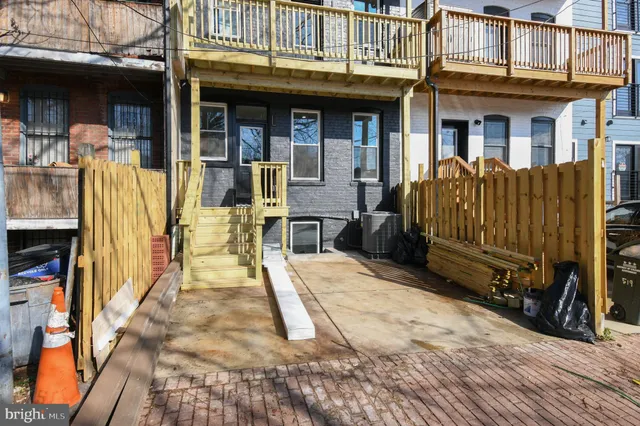 a view of a house with wooden walls and a bench