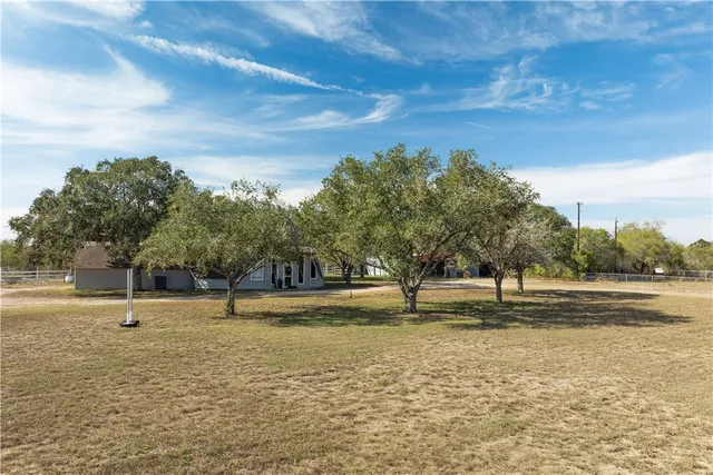 a front view of a house with a yard and large trees