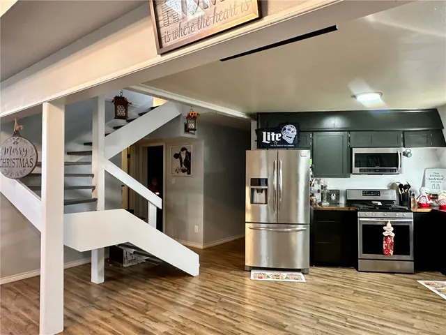 a kitchen with stainless steel appliances kitchen island granite countertop a refrigerator and a stove