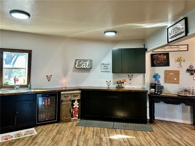 a living room with stainless steel appliances kitchen island granite countertop a sink dishwasher stove and white cabinets