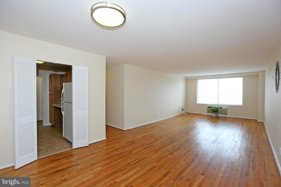 9701 Fields Road, Unit 603 Gaithersburg, MD 20878 - Photo 10 of 29 an empty room with wooden floor and windows