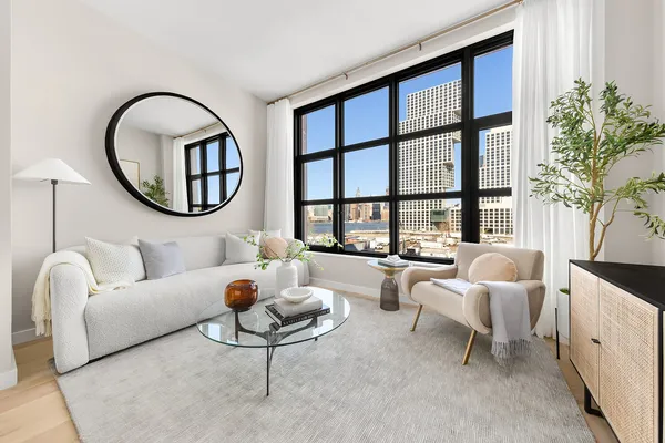 a living room with furniture a fireplace and a large window