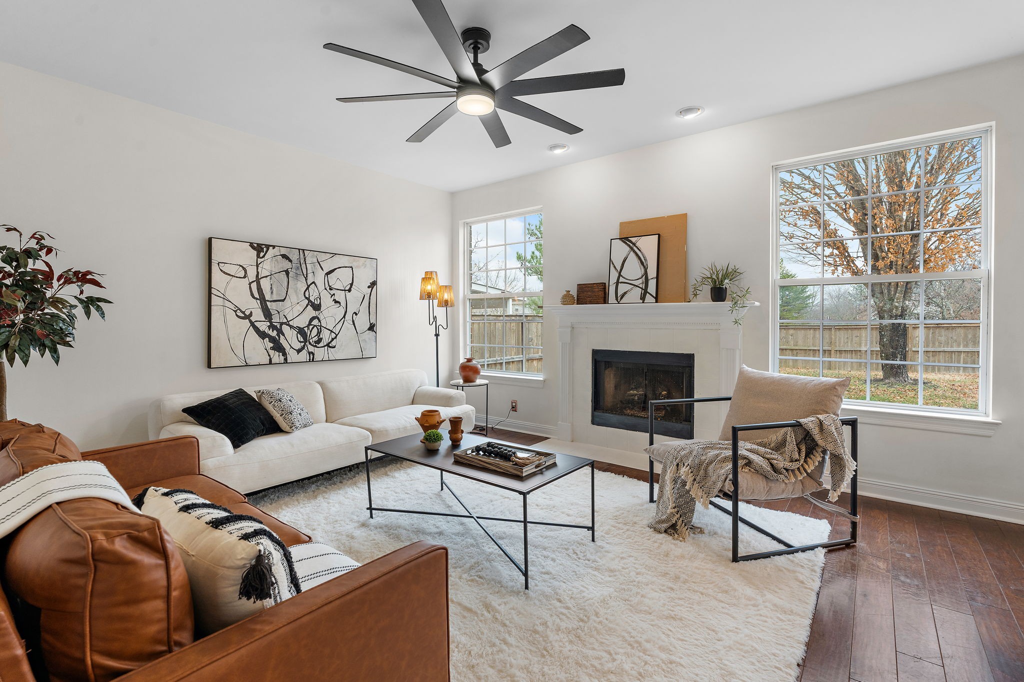 a living room with furniture a large window and a fireplace