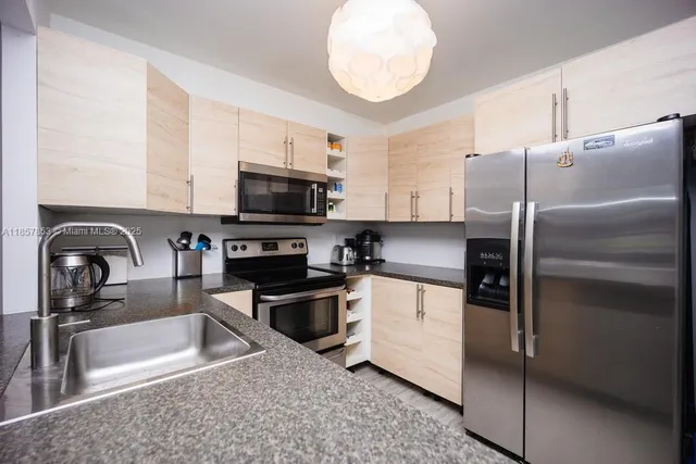 a kitchen with granite countertop a sink and stainless steel appliances