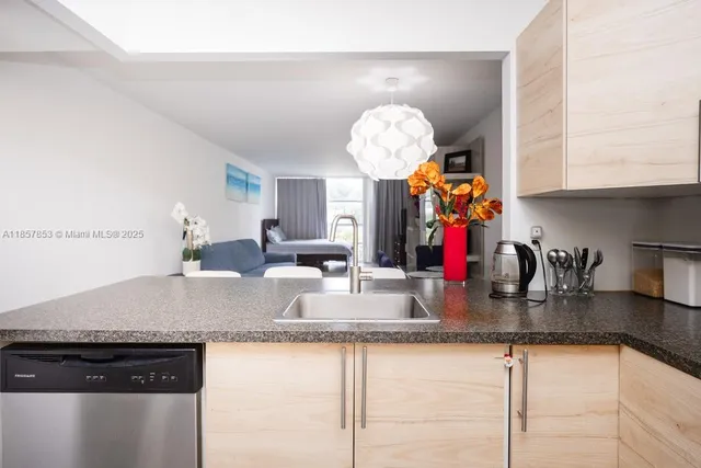 a kitchen with kitchen island granite countertop a sink a stove and cabinets