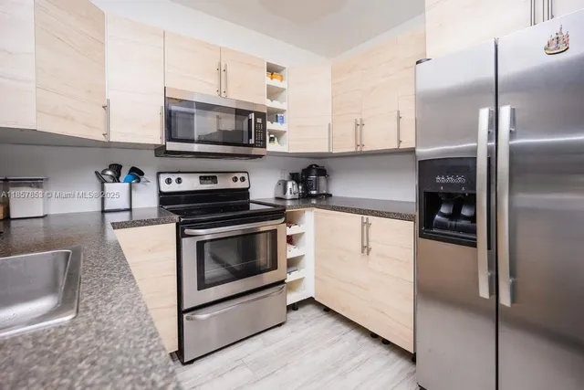 a kitchen with stainless steel appliances granite countertop a refrigerator stove and microwave