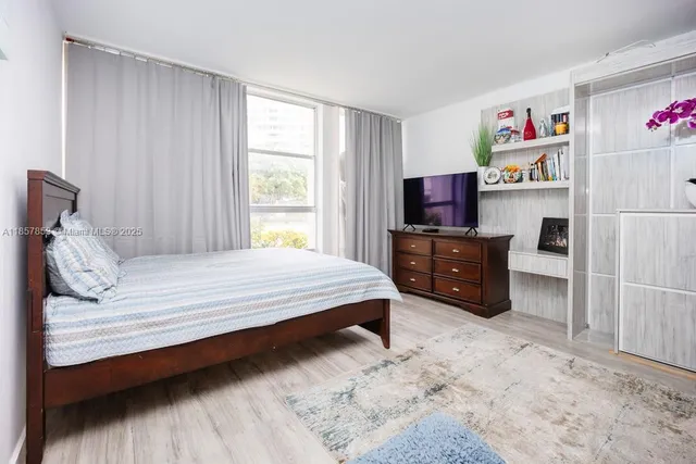 a bedroom with a bed and a flat screen tv