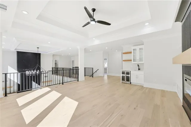 a large white kitchen with stainless steel appliances kitchen island granite countertop a stove a sink and white cabinets