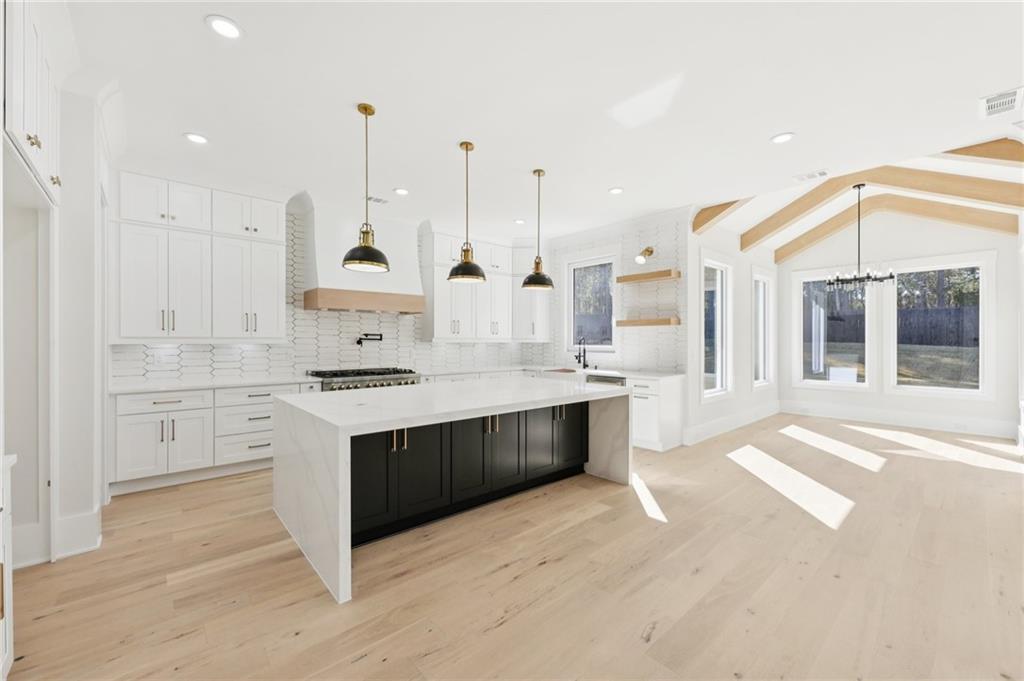 3207 Bold Springs Road Dacula, GA 30019 - Photo 26 of 67 a large white kitchen with stainless steel appliances kitchen island granite countertop a stove a sink and white cabinets