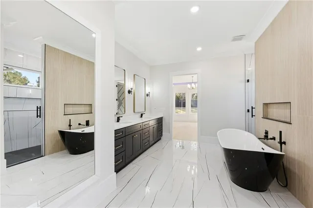 a bathroom with a bathtub shower sink vanity mirror and toilet