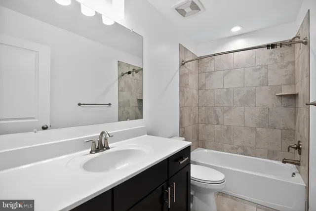 a bathroom with a sink a toilet a mirror a bathtub and shower