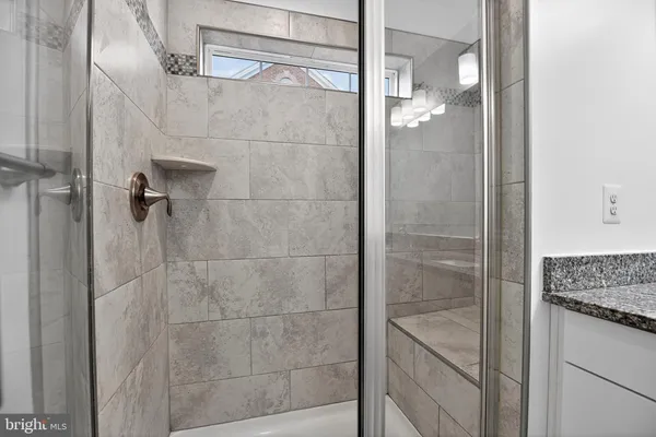 a bathroom with a granite countertop shower