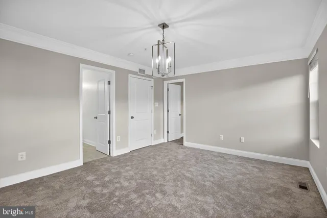 a view of empty room with window and chandelier