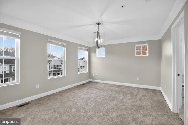 an empty room with windows and chandelier
