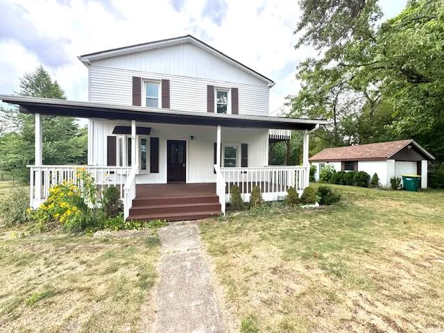 a front view of a house with a yard table and chairs