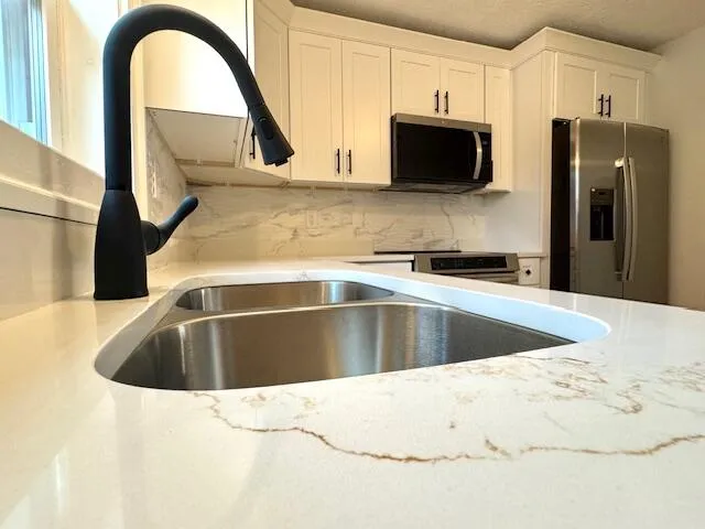 a view of kitchen sink and stainless steel appliances