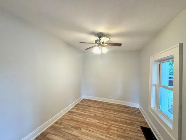 a view of a room with wooden floor and fan