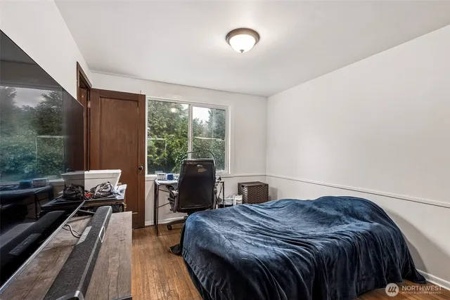 a bedroom with a bed and wooden floor