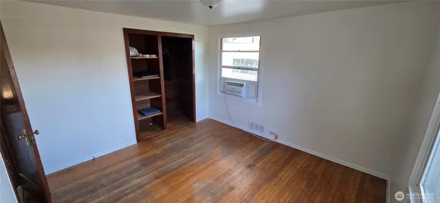 an empty room with wooden floor and closet