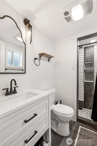 a bathroom with a toilet a sink and mirror