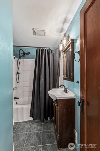 a bathroom with a sink a toilet a mirror and shower