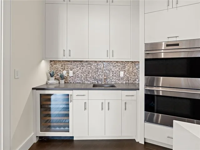 a spacious bedroom with a bed a couch and large window