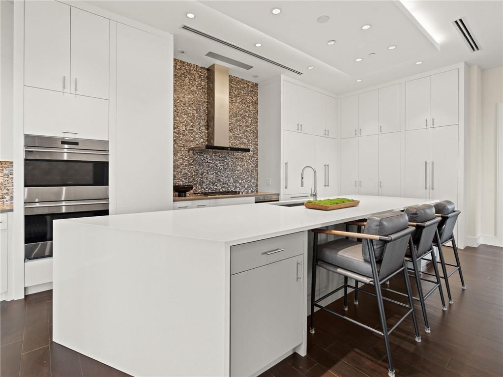 3376 Peachtree Road Northeast, Unit 35B Atlanta, GA 30326 - Photo 24 of 80 a kitchen with stainless steel appliances kitchen island granite countertop a dining table and chairs