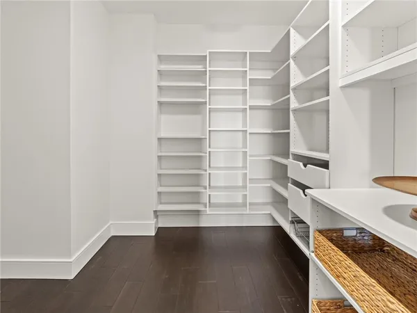 an empty room with wooden floor cabinet and windows